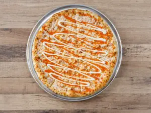 Buffalo Chicken pizza finished with buffalo sauce and ranch