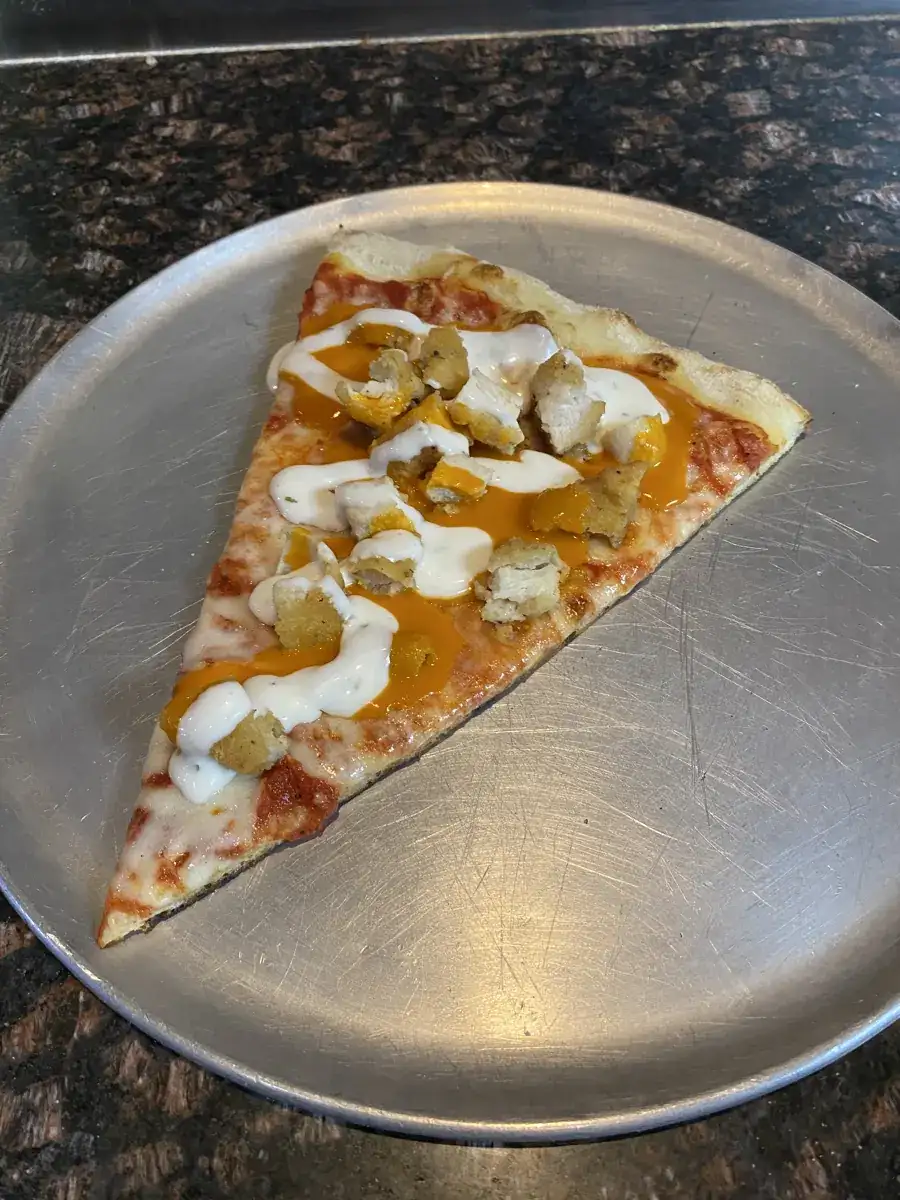 Buffalo Chicken New York-style slice on a metal pizza tray