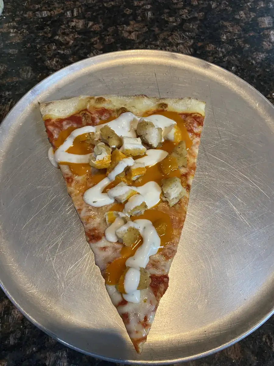 Buffalo Chicken New York-style slice on a metal pizza tray