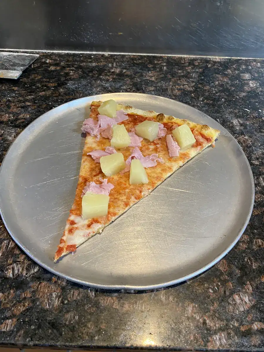Hawaiian New York-style slice on a metal pizza tray