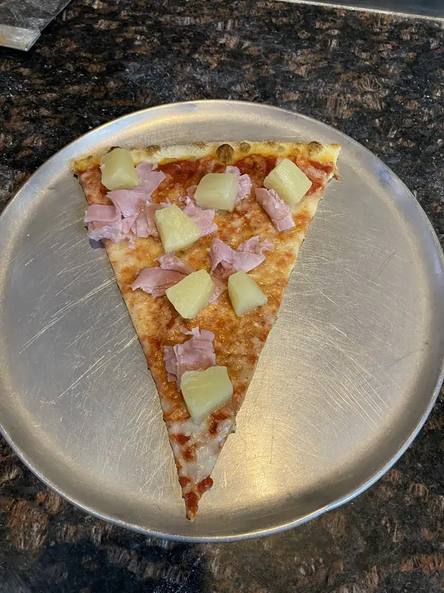 Hawaiian New York-style slice on a metal pizza tray
