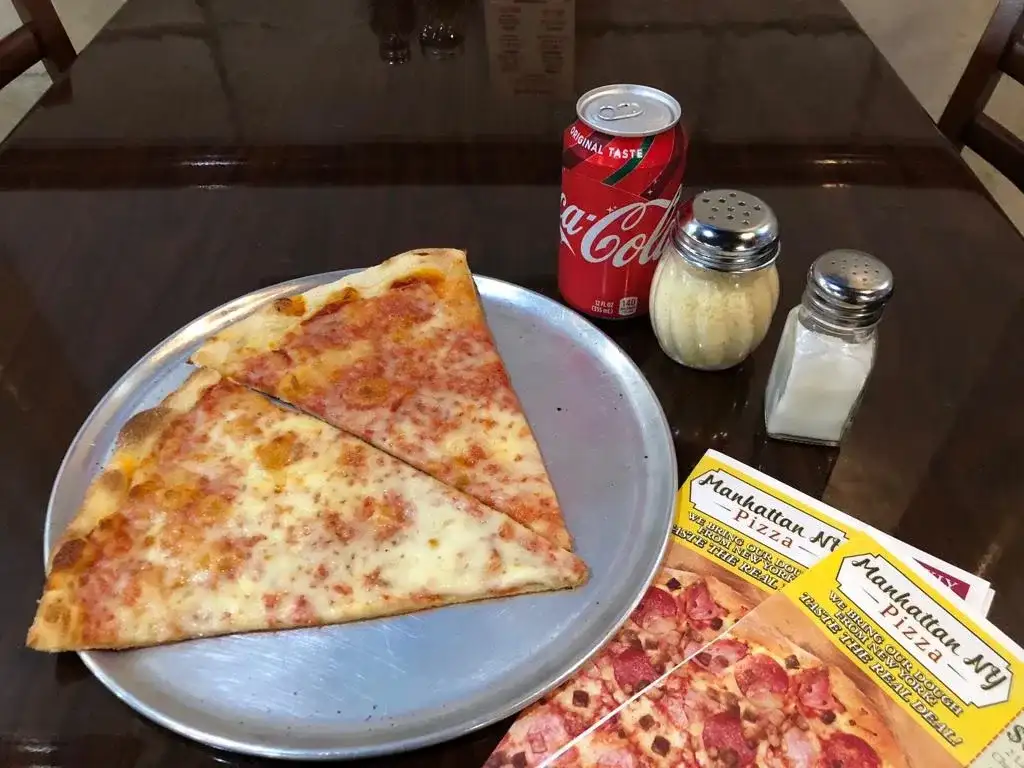 Two New York cheese slices on a tray with a can of soda